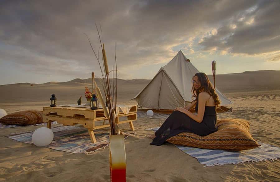 Ica | Huacachina: Desert Glamping | Night Under the Stars - Camp setup in the dunes: kitchen, bar, toilets, and warm lighting